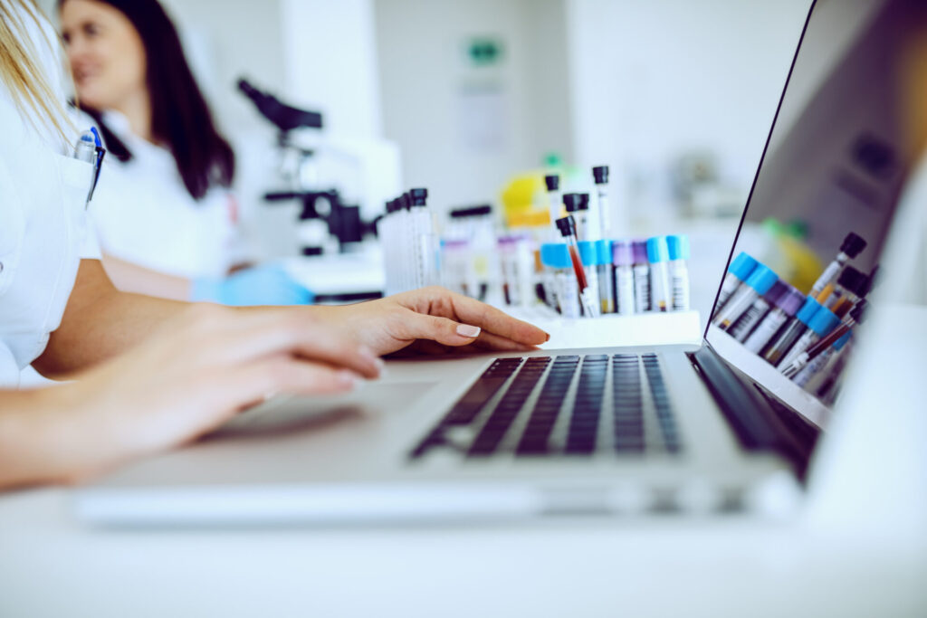 Close up of female lab assistant in white uniform sitting in lab